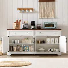 a kitchen with white cupboards and shelves filled with dishes, utensils and other items