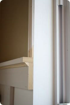 the corner of a room with a door and window sill in front of it