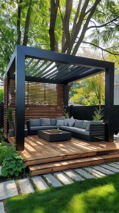 an outdoor living area with wooden decking and black pergoline covering the roof