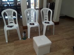 four white plastic chairs sitting on top of a hard wood floor