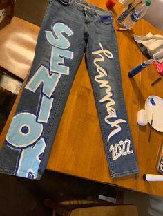 the jeans have been decorated with blue and white letters