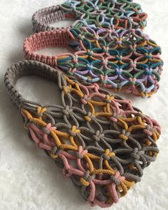 three crocheted purses sitting on top of a white surface next to each other