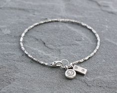 "A unique selection of stamped Thai Hill Tribe fine silver beads are strung together in this rustic beaded bracelet. Finished with two coordinating stamped Thai silver charms and a secure sterling silver lobster clasp. A great everyday piece. Lovely by itself but also pairs well with other bracelets for a stacked look. Total length measures 7 1/2\". Fine silver is .95 to .99 pure silver. Sterling silver is .925 pure silver. Check out other items in my shop here:  https://www.etsy.com/shop/Lindse Thai Silver Jewelry, Cultural Jewelry, Silver Flower Bracelet, Handmade Jewelry Business, Bracelet With Charms, Silver Beaded Bracelet, Hill Tribe Silver, Golden Jewelry, Jewelry Accessories Ideas