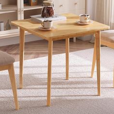 a wooden table with two chairs and a coffee cup on it