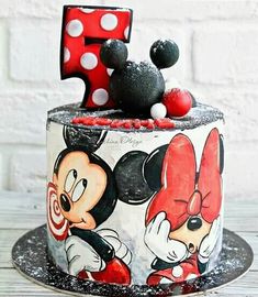 a mickey and minnie mouse cake with the number one on it's top tier