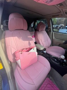 the interior of a car with pink leather seats and handbags on it's side