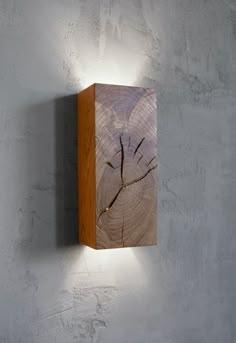 a wooden wall light mounted to the side of a white wall