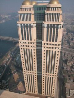 an aerial view of a tall building with two domes on it's sides and the city below