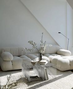 a living room with a white couch and coffee table in front of an angled wall