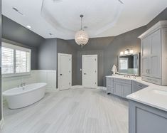 a large bathroom with gray walls and white fixtures