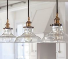 three lights hanging from a ceiling in a kitchen