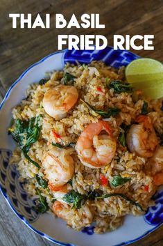 thai fried rice with shrimp and spinach served on a blue and white plate next to a lime wedge