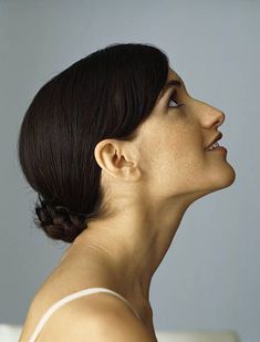 a woman with her head turned to the side looking up at something in the air