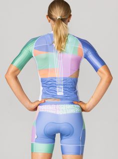 the back of a woman's cycling suit with colorful stripes on it and her hands on her hips