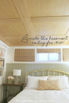 a bed sitting under a wooden ceiling next to a book shelf with books on it