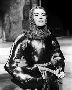 a woman dressed in armor with a helmet and chain around her neck is posing for the camera