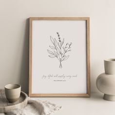 a framed print with the words, my god will always carry you on it next to a cup and saucer