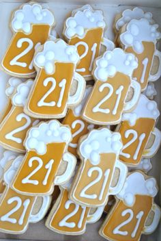 decorated cookies in the shape of beer mugs with white frosting and numbers on them