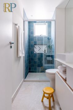 a bathroom with blue tiles and a white toilet next to a walk - in shower