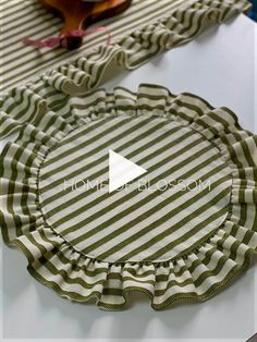 a green and white striped paper plate with ruffles on the edge, sitting on a table