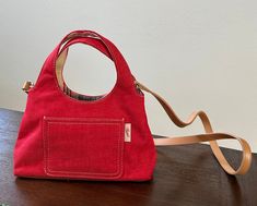 "Vintage Red Denim material Fossil purse with Neutral brown Crossbody straps. Beautiful like new condition. Approximate measurements:  10\"L x 4\"W x 10\"H (from the hand strap) Had a small Velcro pocket on front side of purse with the Fossil tag. Inside is beautiful striped material and red lining with the Fossil mark.  Has zippered side pocket inside and additional pocket on other side." Vintage Red Shoulder Bag For Summer, Everyday Red Shoulder Bag With Snap Closure, Vintage Red Crossbody Shoulder Bag, Red Vintage Shoulder Bag With Leather Lining, Red Crossbody Shoulder Bag With Zipper Pocket, Fossil Purse, Red Denim, Brown Crossbody, Hand Strap