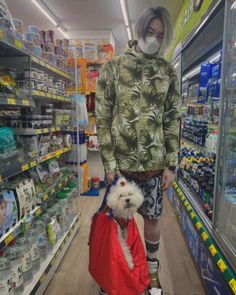 a person with a dog on a leash in a grocery store aisle wearing a face mask