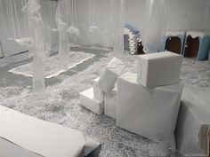 a room with white furniture and lots of plastic sheets on the floor in front of it