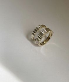 a gold and diamond ring on a white surface