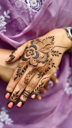 a woman's hand with henna tattoos on it