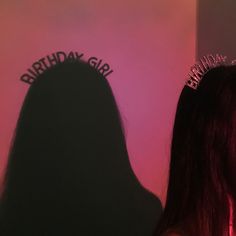 a woman wearing a tiara standing in front of a wall with the words birthday girl on it