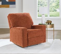 an orange recliner sitting on top of a white rug