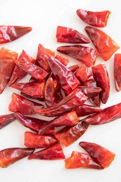 red peppers cut up and placed on a white surface with the peels still attached