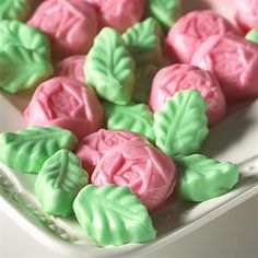 some pink and green cookies on a white plate