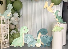 a birthday party with balloons and decorations for a baby's first birthday, including dinosaur figurines