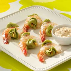 shrimp and avocado rolls on a plate with dipping sauce