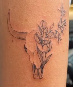 a cow skull with flowers on it's side tattoo design by the talented artist