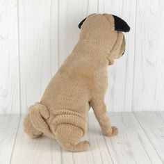 a dog stuffed animal sitting on top of a white wooden floor next to a wall