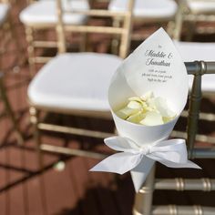 a bouquet of flowers sitting on top of a white table cloth covered chair with ribbon