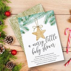 a merry little baby shower card next to some candy canes and pineconi