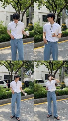 the man is wearing blue jeans and a white t - shirt while standing in front of some trees