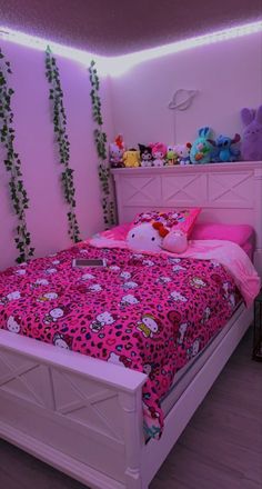 a pink bedroom with hello kitty bedding and green vines on the wall behind it