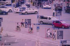 an intersection with cars, people and bicycles on the crosswalk in front of them