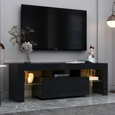 an entertainment center with a large flat screen tv mounted on the wall above it, in a living room