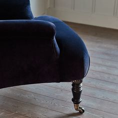 an upholstered blue chair on wooden flooring