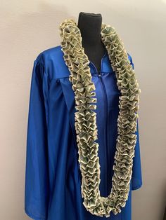 a blue graduation gown with ruffles on the front and bottom, along with a black mannequin headdress