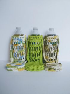 four crocheted canisters are lined up next to each other