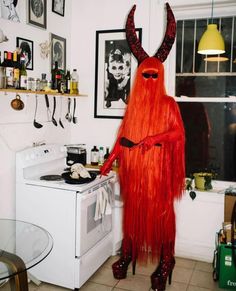 a red devil is standing in the kitchen