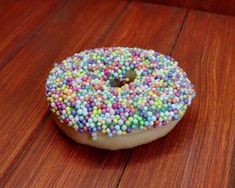 a sprinkled donut sitting on top of a wooden table