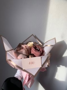 a bouquet of flowers sitting inside of a box on top of a table next to a wall