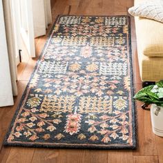 a rug on the floor in a living room next to a couch and planter